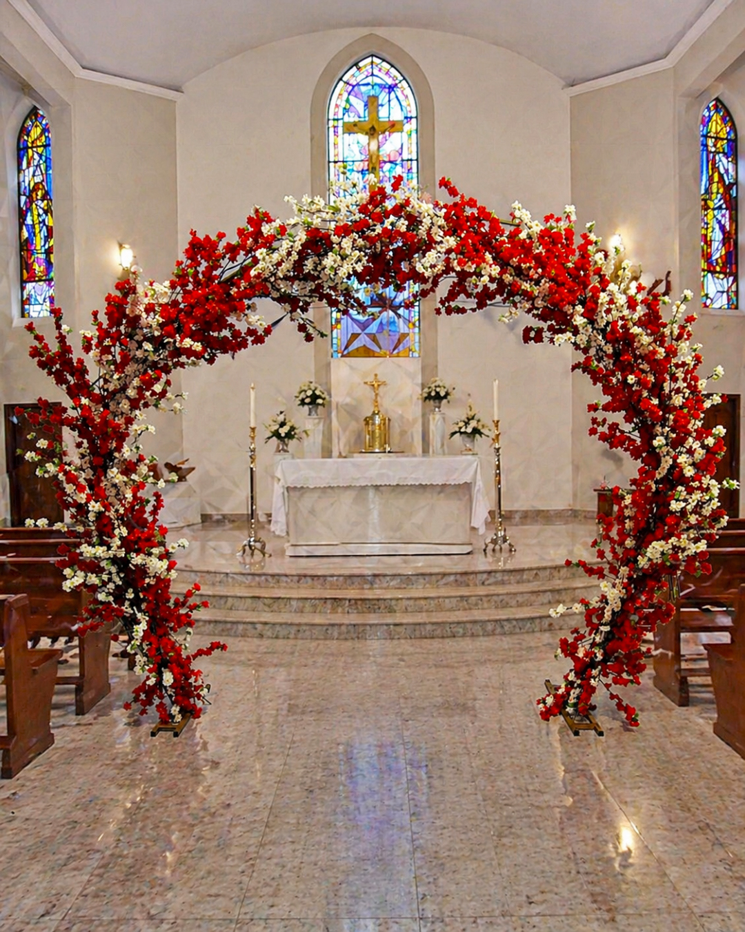 Arco floral de cerejeiras para cerimônia de casamento com flores vermelhas e brancas, ideal para entrada dos noivos e composição decorativa elegante